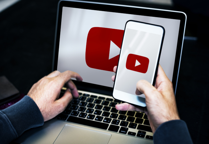 Businessman using a laptop and a mobile phone mockup YouTube on laptop and cellphone