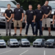 Group of people standing in front of cars