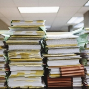 Stacks of papers representing the process and paperwork used in a business lien search process