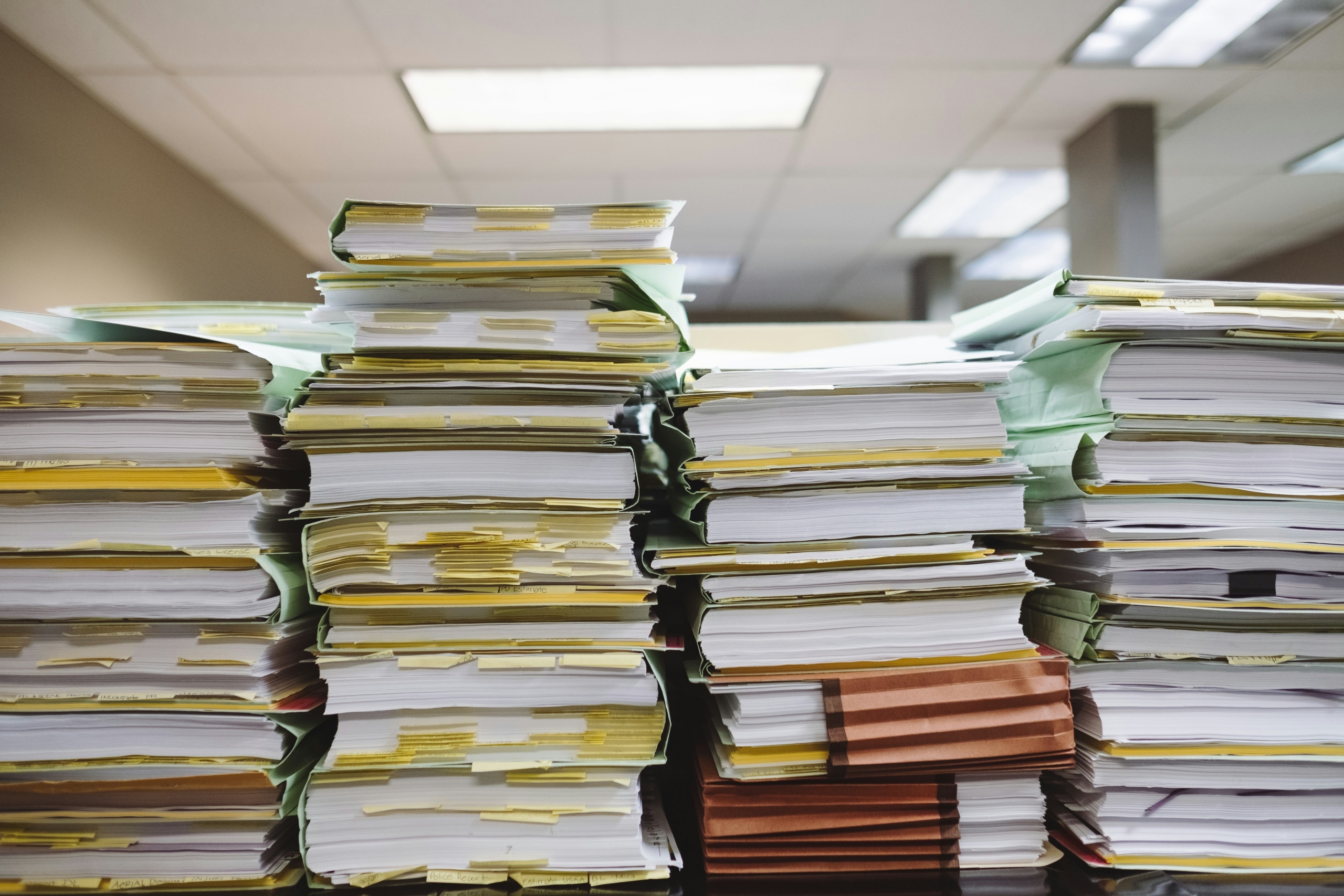 Stacks of papers representing the process and paperwork used in a business lien search process